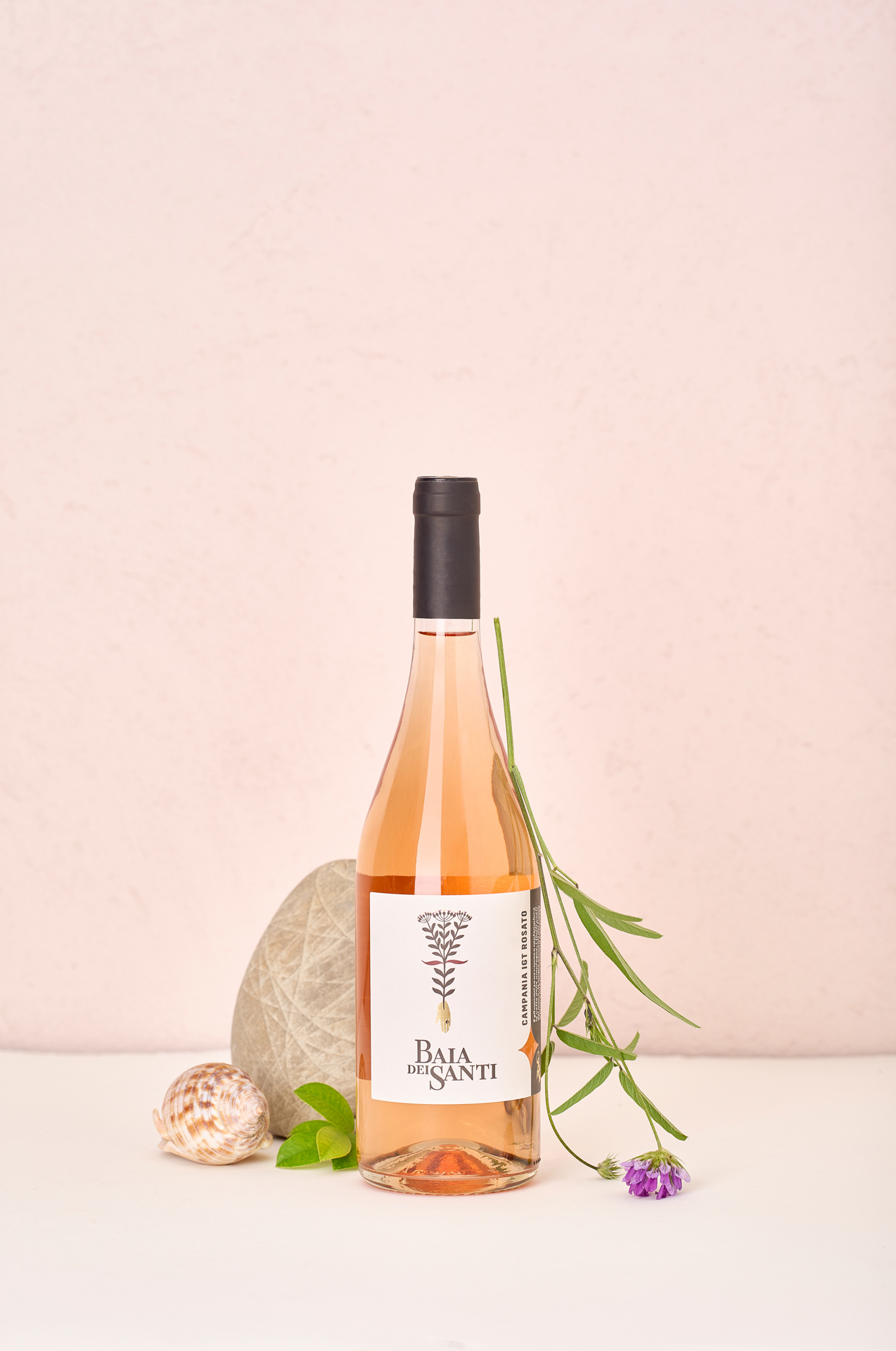 Bottiglia del vino Campania IGT Rosato di Baia DeiSanti con fiore, conchiglia e sasso
