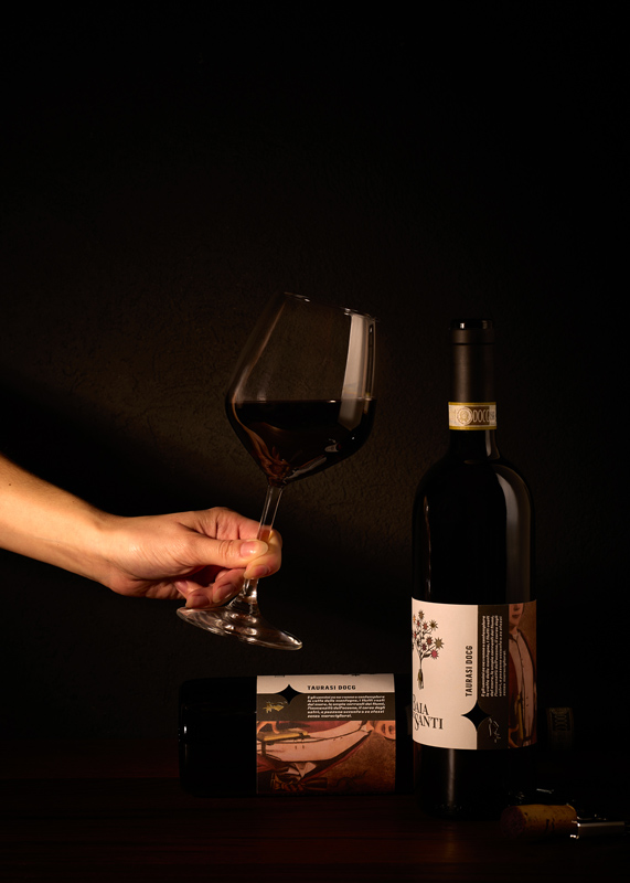 Bottiglia del vino Taurasi DOCG di Baia DeiSanti con mano che regge un calice